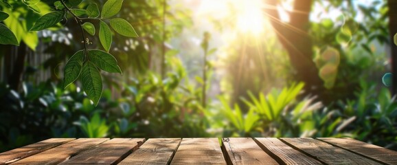 Abstract blank wooden tabletop over blurred green plant in garden background with morning sunligh