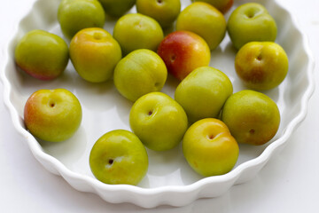Fresh green plum on white background