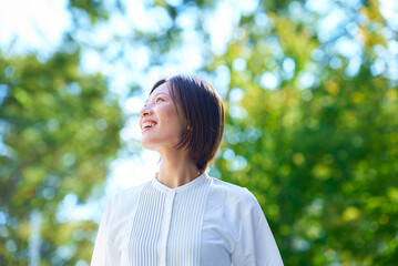 晴天の緑の中でくつろぐ女性