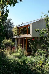 A modern house nestled among lush greenery, featuring concrete walls and wooden accents, blending harmoniously with its natural surroundings.