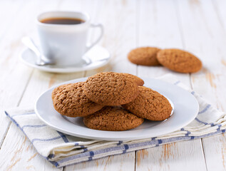 Oatmeal cookies and coffee on a white table, selective focus.
