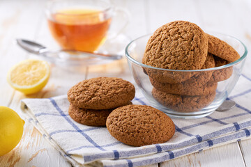 Oatmeal cookies and tea on a white table, close up.