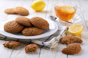 Low-calories oatmeal cookies and tea on a light kitchen table, selective focus.