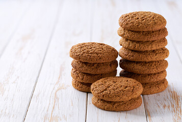 Small pile of delicious oatmeal cookies  with a light kitchen table, selective focus.