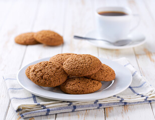 Oatmeal cookies and coffee on a white table, selective focus.