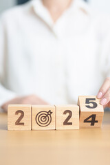 Naklejka premium 2024 year change to 2025 year block with dartboard icon. Goal, Target, Resolution, strategy, plan, Action, mission, motivation, and New Year start concepts