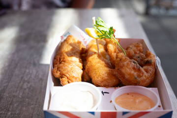 A mouth-watering meal of crispy fish, shrimp, and chicken, served with golden fries. The perfectly battered seafood and chicken are fried to a golden crisp