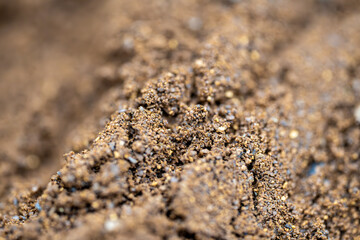 This close-up photograph reveals the rich texture and intricate detail of freshly ground coffee. The fine particles, ranging in color from deep brown to light tan, are captured in sharp focus.