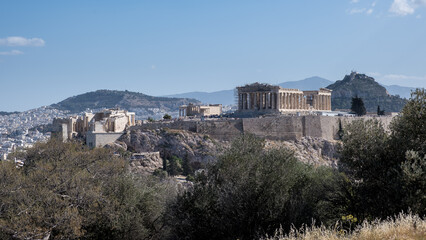View of the Acropolis of Athens from Mouseion Hill, located to the southwest. The Acropolis contains the remains of several significant ancient buildings, including the Parthenon.