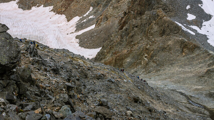 Climbers goes in raw heavy rocks path france normal way to top Mont Blanc in good conditions