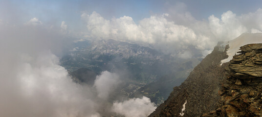 Steep huge rocky way to old unused Goûter refuge engulfed in snow with valley background