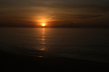 The sun rises at the sea in the morning.