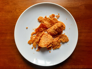 processed from tempeh, namely tempeh chips that are given spicy and salty seasoning on a white plate