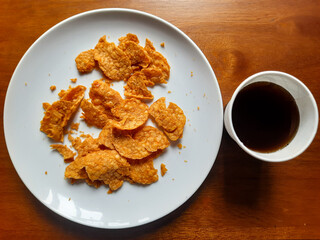 processed from tempeh, namely tempeh chips that are given spicy and salty seasoning on a white plate