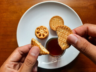 various kinds of biscuits that are usually eaten at breakfast accompanied by a glass of hot coffee on a white plate