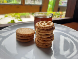 various kinds of biscuits that are usually eaten at breakfast accompanied by a glass of hot coffee on a white plate