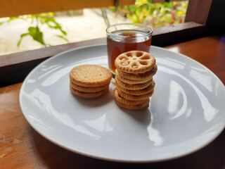 various kinds of biscuits that are usually eaten at breakfast accompanied by a glass of hot coffee on a white plate