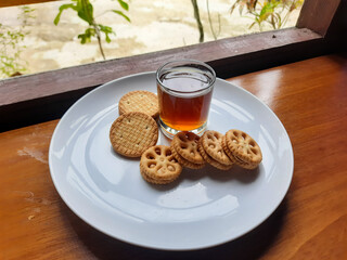 various kinds of biscuits that are usually eaten at breakfast accompanied by a glass of hot coffee on a white plate