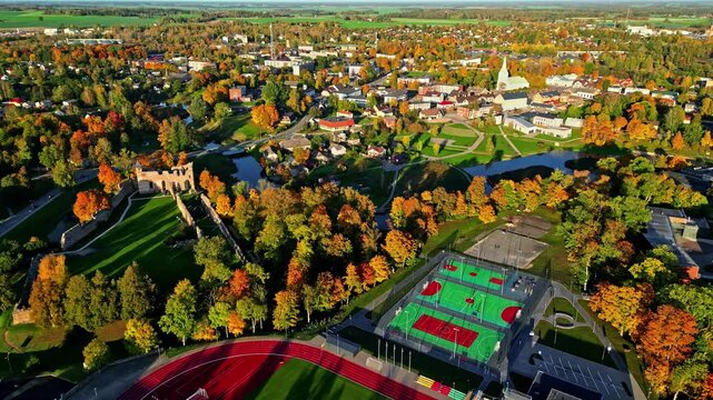 Dobele town with trees fall foliage, drone view of Castle Ruins on Berze river