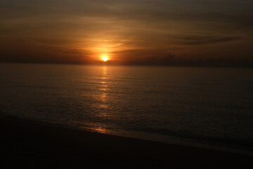 The sun rises at the sea in the morning.