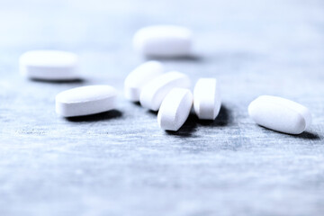 Amino acids tablets. Nutrition for bodybuilding. Fitness supplements on bright wooden background. Soft focus. Copy space.	