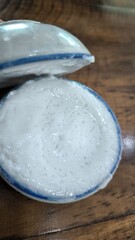 Thai dessert (khanom thuay) coconut milk custard in small porcelain cup .