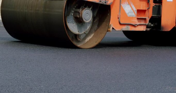 Asphalt laying. Road building asphalt paver is laying a new layer of asphalt, Road rollers drive on a new road. Roadway repair. Heavy machinery. Asphalt Road Construction.