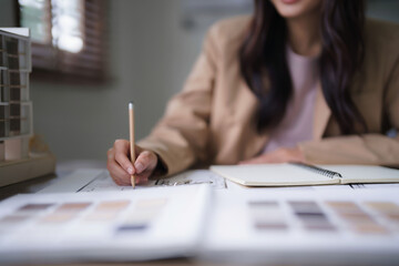 Female architect work to designing architecture interior and drawing building project on blueprint