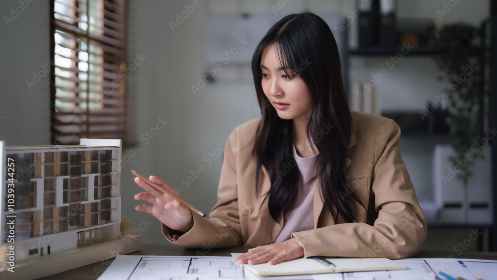 Poster female architect looking on building model and designing architecture interior project on blueprint
