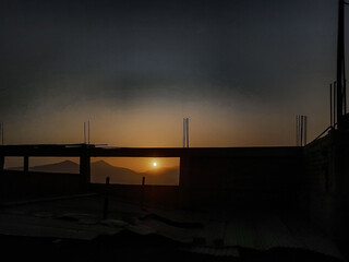 Ocaso en la ciudad de colores dorados y azul con fondo de monta&ntilde;as