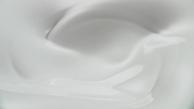 Slow motion of milk, cream, ice cream, yogurt mixture stirring and swirling