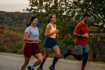 Shot of a fitness group running along a rural highway