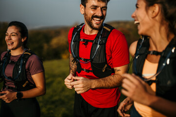 A small group of happy athletic people running a marathon race in the nature