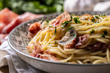 Traditional Italian spaghetti with prosciutto, mushrooms and parmesan