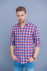 Fototapeta premium Confident millennial young man with unshaven face and stylish hairstyle isolated on grey