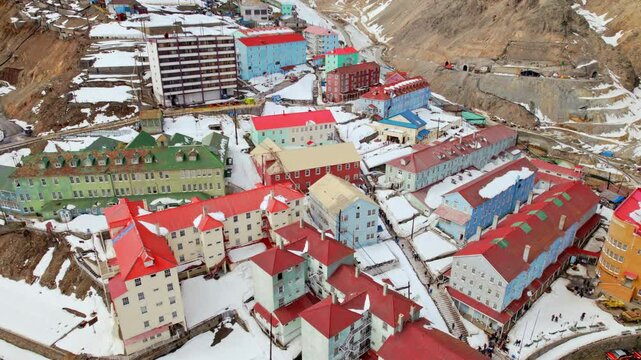 Colorful buildings with vibrant roofs in a snowy mountain town in Sewell, Chile, aerial view