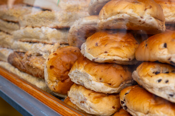 Freshly baked buns are displayed in a bakery window