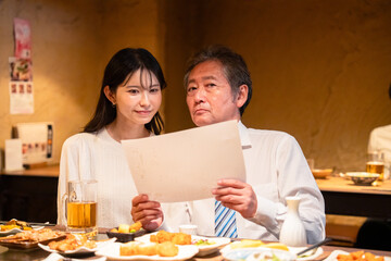 若い女性と二人でお酒を飲む男性