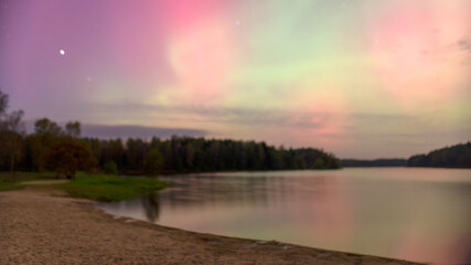 Fototapeta premium color photo with beautiful northern lights in the sky, northern lights over the lake