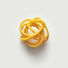 Fototapeta premium A yellow rubber band ball resting on a plain white surface.