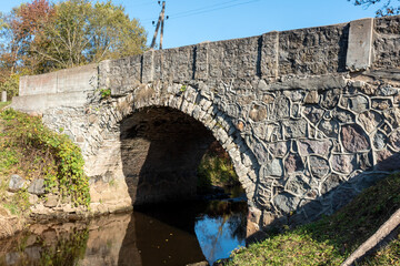 Fototapeta premium autumn landscape with a stone arched bridge over Vizla near Vidagas, Vidagas village, Latvia