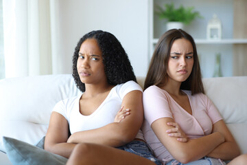 Angry interracial friends ignoring each other