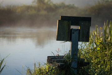 FISHING SPOT - Wooden chair on the river bank in the morning

