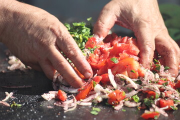 cook preparing tomato salad for turkish adana kebap