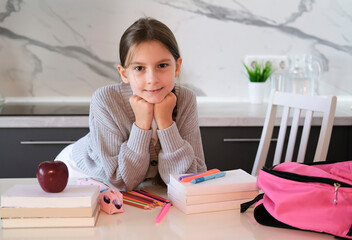 Student packing her pink backpack before leaving for school. Concept of education and development...
