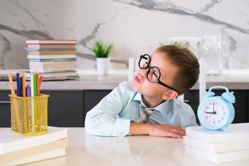 Happy kid in tie and shirt is messing around with schoolwork. Concept of teaching and educational...