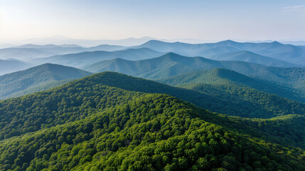 Obraz premium scenic aerial view of lush green mountains, showcasing rolling hills and serene landscape under clear sky. beauty of nature is truly captivating