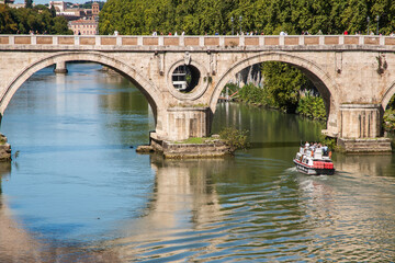 Naklejka premium Old bridge over the Tiber River with water reflection in Rome, Italy 
