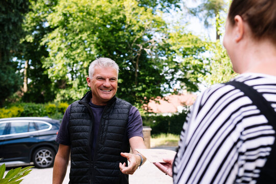 Smiling workman getting paid through paycheck