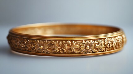 Antique gold bangle with ornate carvings displayed on a clean minimalistic surface highlighting its historical charm and intricate craftsmanship